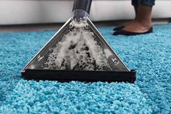 person using an at home carpet cleaner